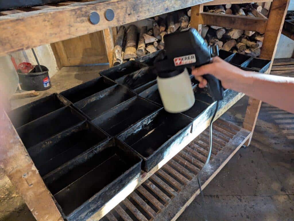 Action shot of KREAYTIVITY foodSPRAYER Pro at artisan bakery in Spain geasing their baking moulds